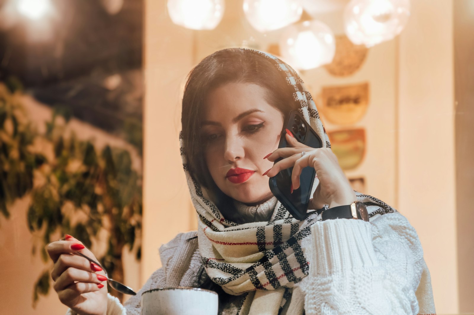 A woman with a coffee sending a message on her phone